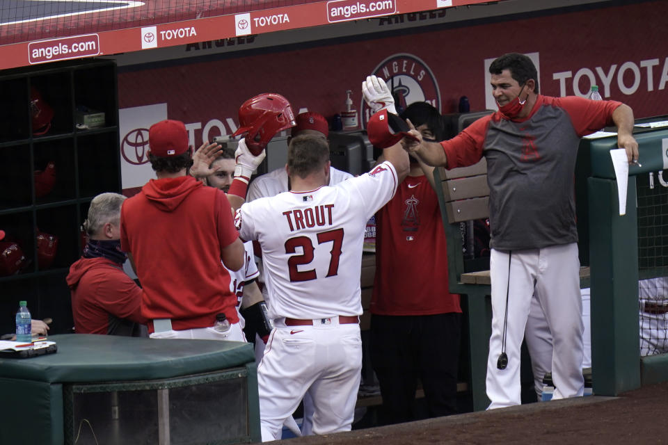 Los Angeles Angels' Mike Trout, center, celebrates his two-run home run with teammates in the dugout during the third inning of the first baseball game of a doubleheader against the Houston Astros, Saturday, Sept. 5, 2020, in Anaheim, Calif. (AP Photo/Jae C. Hong)