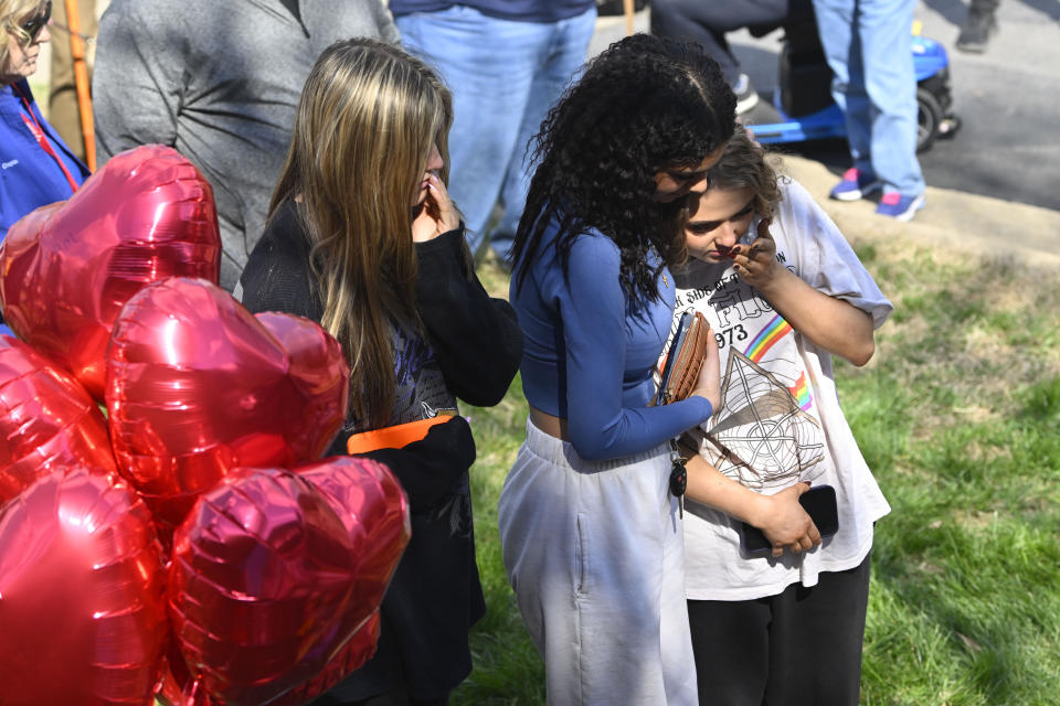 People console and pay respect as they visit an entry to Covenant School which has become a memorial for victims, Tuesday, March 28, 2023, in Nashville, Tenn. Six people were killed at the private school and church yesterday by a shooter. (AP Photo/John Amis)