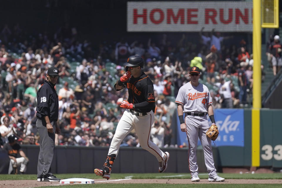 San Francisco Giants' Blake Sabol, center, gestures toward teammates in front of Baltimore Orioles third baseman Josh Lester, right, after hitting a two-run home run during the sixth inning of a baseball game in San Francisco, Sunday, June 4, 2023. (AP Photo/Jeff Chiu)