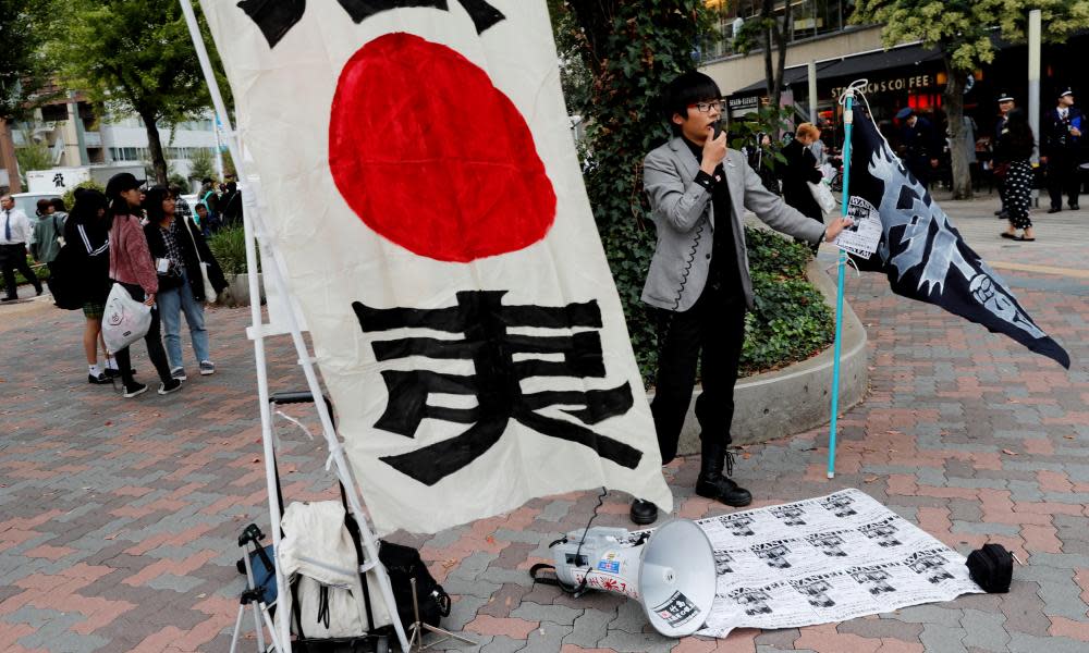 A man denounces South Korean boy band BTS outside Tokyo Dome