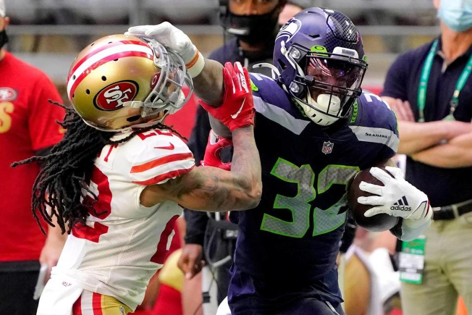 Seattle Seahawks running back Chris Carson (32) stiff arms San Francisco 49ers cornerback Jason Verrett (22) during the first half of an NFL football game, Sunday, Jan. 3, 2021, in Glendale, Ariz. (AP Photo/Rick Scuteri)