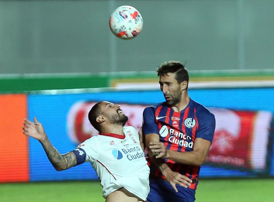 Choque de zagueros; José Moya y Alejandro Donatti, en un cuerpo a cuerpo aéreo en pos de la pelota.