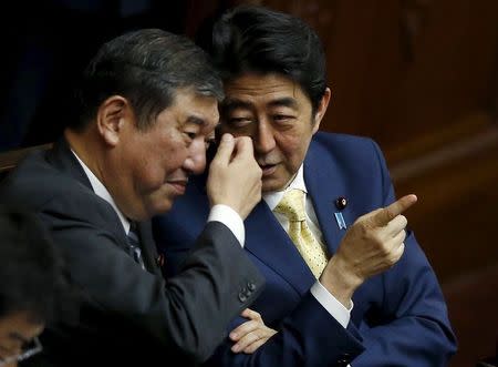 Japan's Prime Minister Shinzo Abe (R) talks with minister in charge of reviving local economies Shigeru Ishiba during the plenary session of the parliament in Tokyo July 16, 2015. REUTERS/Toru Hanai