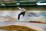 Blind Japanese skateboarder Ryusei Ouchi trains at a skatepark holding a cane in Tokorozawa