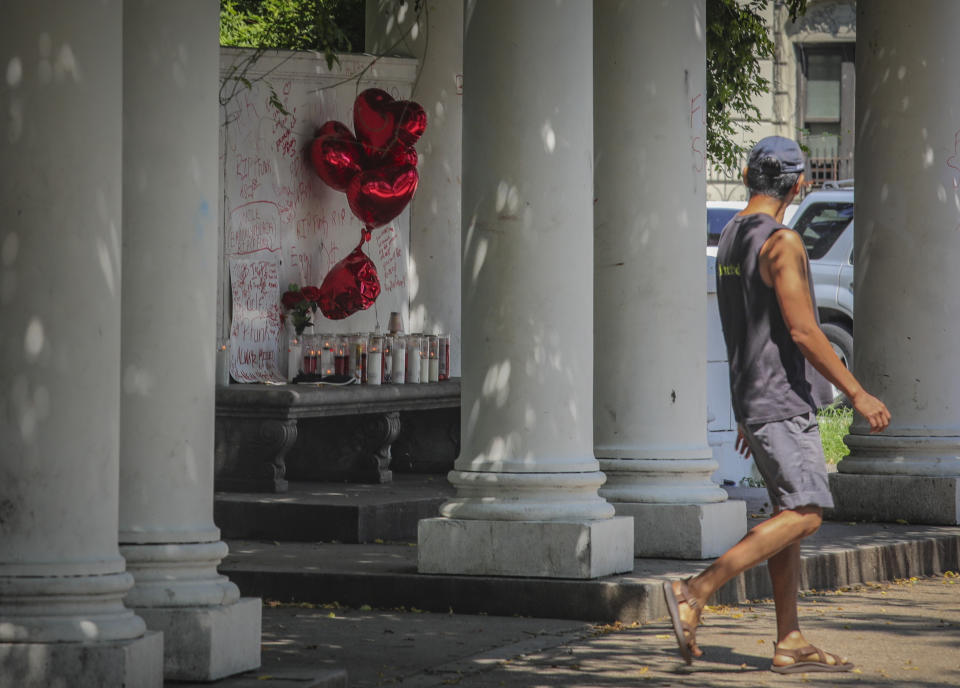 Heart-shaped balloons and candles mark the spot at the entrance to Prospect Park where 47-year-old Paul "P-Funk" Pinkney was murdered over the past weekend, Monday, Aug. 17, 2020, in New York. President Donald Trump is again threatening to send federal agents to New York City if local authorities don't stop a surge of violence that has left seven people dead and more than 50 people shot since Friday. (AP Photo/Bebeto Matthews)
