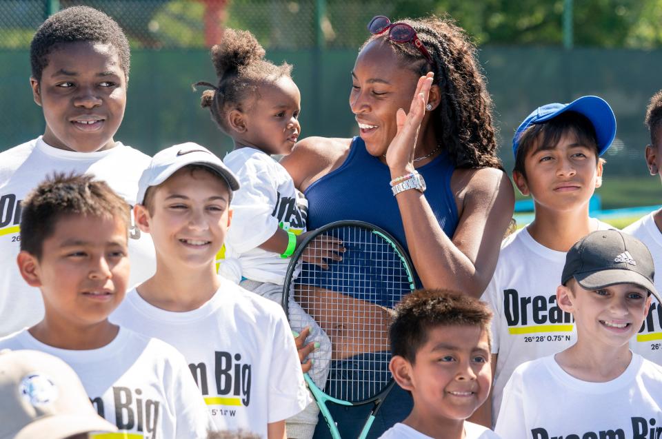 Coco Gauff holds Jonathan Charles, 2, during a photo with kids attending a ceremony to celebrate the two refurbished public tennis courts at Pompey Park as part of USTA's US Open Legacy Initiative, which was created in celebration of Gauff's 2023 U.S. Open women's singles on March 19, 2024 in Delray Beach, Florida.