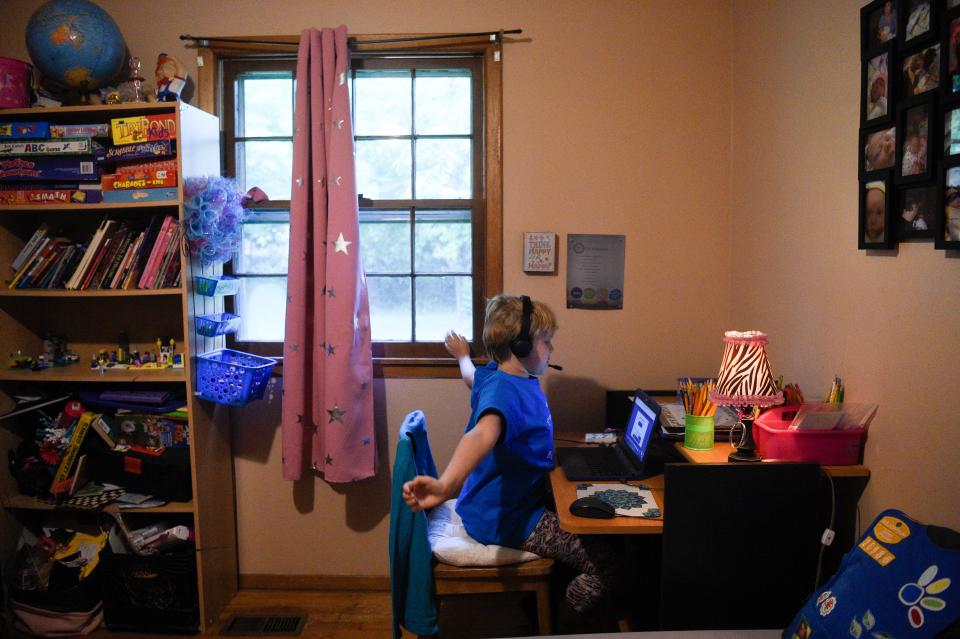 Olivia Sexton, 8, stretches at the cue of her teacher as she attends her first day of third grade virtually from her home in Knoxville, Monday, Aug. 24, 2020.