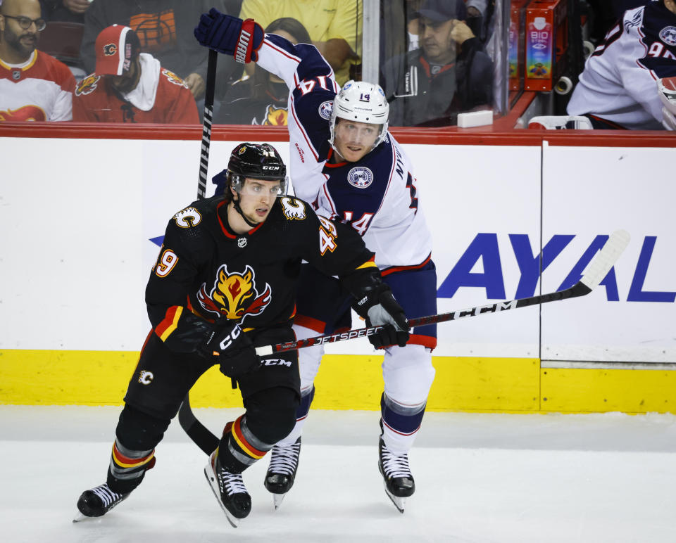 Columbus Blue Jackets forward Gustav Nyquist, right, and Calgary Flames forward Jakob Pelletier chase a play during second-period NHL hockey game action in Calgary, Alberta, Monday, Jan. 23, 2023. (Jeff McIntosh/The Canadian Press via AP)