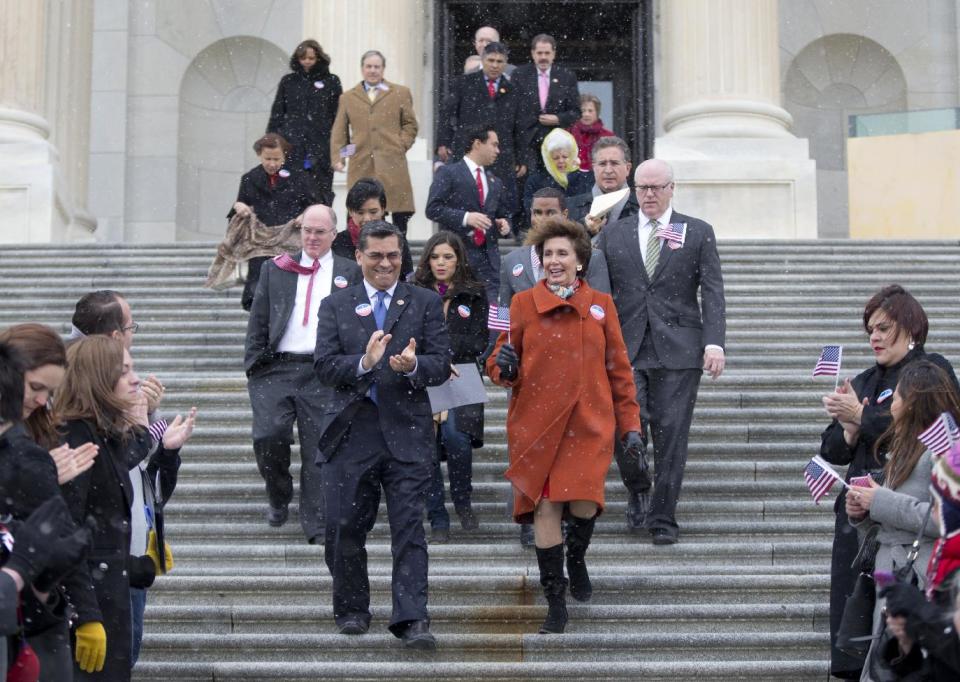 Rep. Xavier Becerra, D-Calif., left, and House Minority Leader Nancy Pelosi of Calif., walk with other House Democrats and immigration leaders to gather on the steps of the Capitol in Washington, Wednesday, March 26, 2014, for a new conference to announce a DemandAVote discharge petition and call on House Speaker John Boehner of Ohio, and the House Republican Conference to bring up immigration reform bill H.R. 15. Also seen is actress America Ferrera, behind and between Pelosi and Becerra. (AP Photo/Carolyn Kaster)