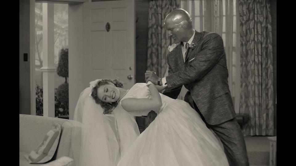 Vision dips Wanda in a wedding dress in a black-and-white 1950s sitcom-style household.