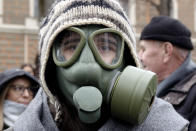 A person wearing a gas mask takes part in a protest against air pollution, in Sarajevo, Bosnia, Monday, Jan. 20, 2020. Dozens of people, some wearing face masks, gathered for a protest because of dangerously high levels of air pollution in the past weeks in the Bosnian capital after measurements in the past weeks have shown that levels of damaging airborne particles have exceeded European Union's safety norms by several times.(AP Photo/Eldar Emric)