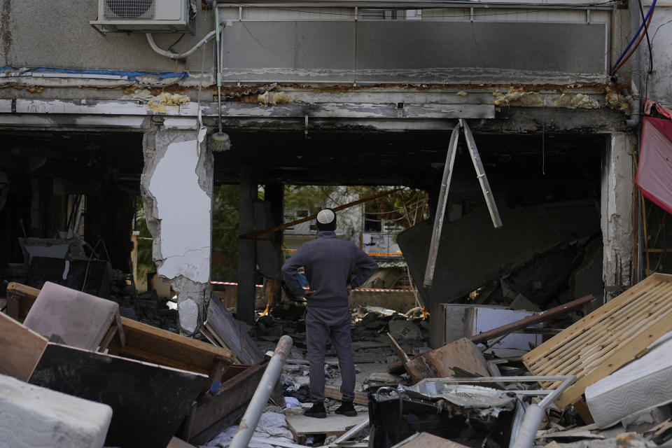 A man looks at destruction made by a rocket fired from the Gaza Strip in Ashkelon, Monday, Oct. 9, 2023. Israel's military battled to drive Hamas fighters out of southern towns and seal its borders Monday as it pounded the Gaza Strip from the air. (AP Photo/Ohad Zwigenberg)