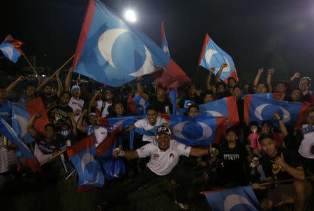 Supporters of Mahathir Mohamad, former Malaysian prime minister and opposition candidate for Pakatan Harapan (Alliance of Hope), celebrate outside the hotel, where Mahathir Mohamad held news conference, in Petaling Jaya, Malaysia, May 10, 2018. REUTERS/Athit Perawongmetha