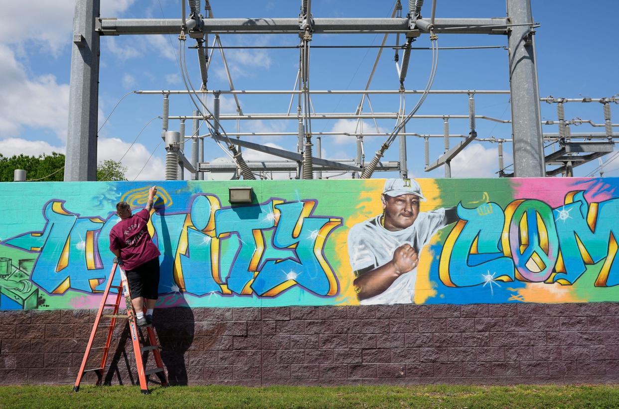 Amando “Taner” Martinez paints a mural at the decommissioned Holly Power Plant Wednesday April 10, 2024.