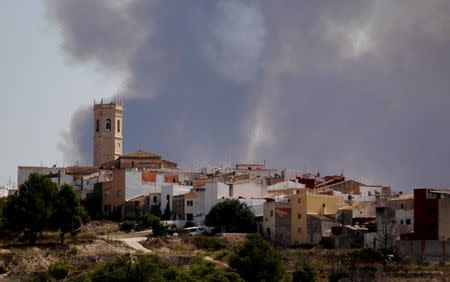 The smoke of a wildfire is seen behind the village of Teulada near Alicante, Spain September 5, 2016. REUTERS/Heino Kalis