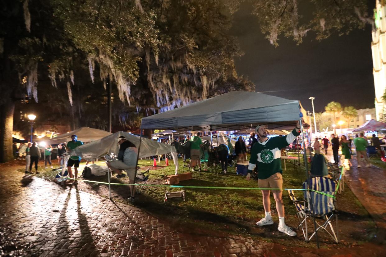 Parade goers rush to set up tents in Lafayette Square after the 6am opening before the start of the Savannah St. Patrick's Day parade on Saturday, March 16, 2024.