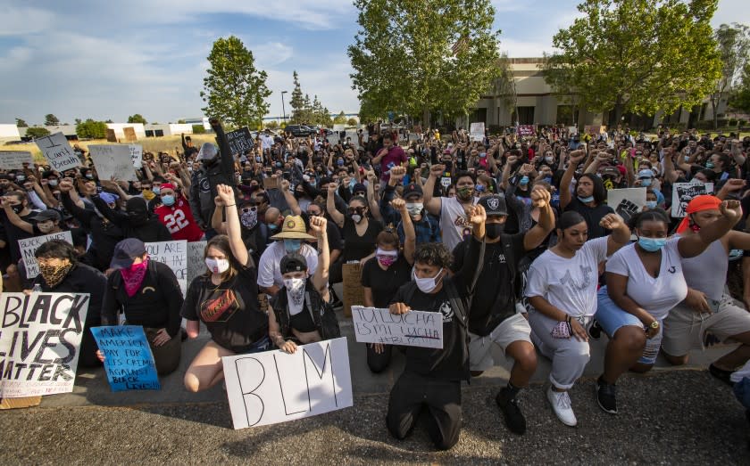 MORENO VALLEY, CA - JUNE 2, 2020: Hundreds of demonstrators take a knee to protest the death of George Floyd in front of the police station during the coronavirus pandemic on June 2, 2020 in Moreno Valley, California. (Gina Ferazzi / Los Angeles Times)