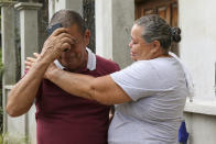 Jose Santos Bueso, father of Jazmin Nayarith Bueso, is comforted by a neighbor at his home in El Progreso, Honduras, Thursday, June 30, 2022. Nayarith Bueso was among the more than 50 migrants who were found dead inside a tractor-trailer near San Antonio, Texas. (AP Photo/Delmer Martinez)