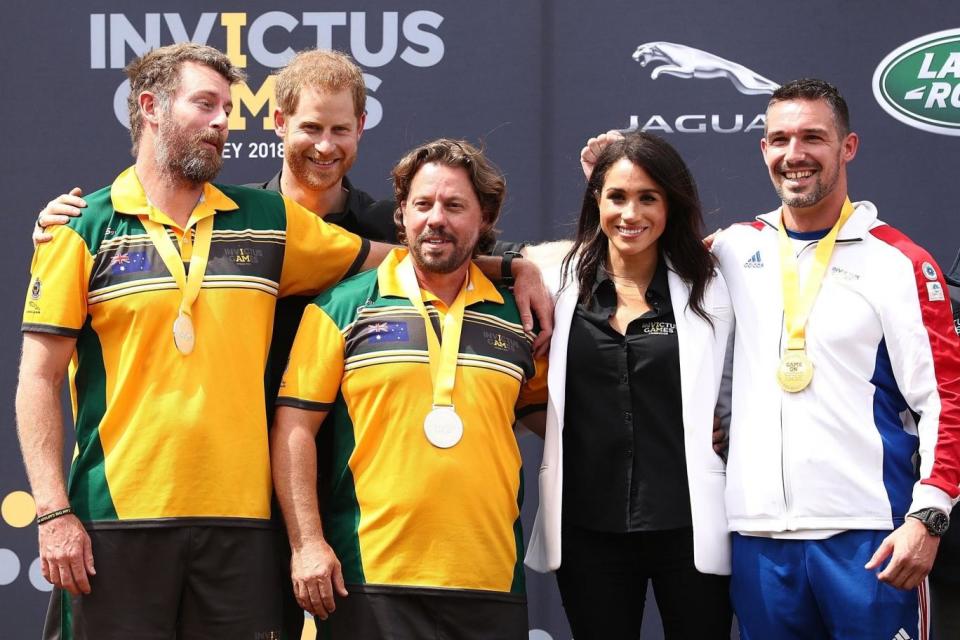 Harry and Meghan pose with gold medalists Cedric Arci and Michael Ranchin of France and Silver medallists Craig McGrath and Scott Reynolds of Australia during the medal ceremony of the JLR Drive Day (Getty Images)