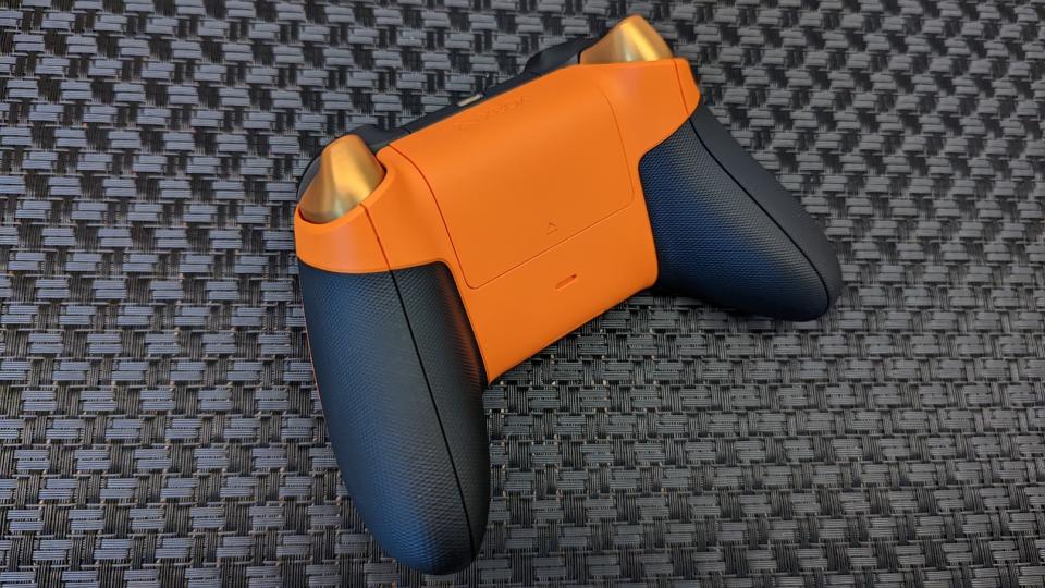 The back of an orange Xbox controller on a black patterned surface. (Photo: Yahoo Gaming SEA)