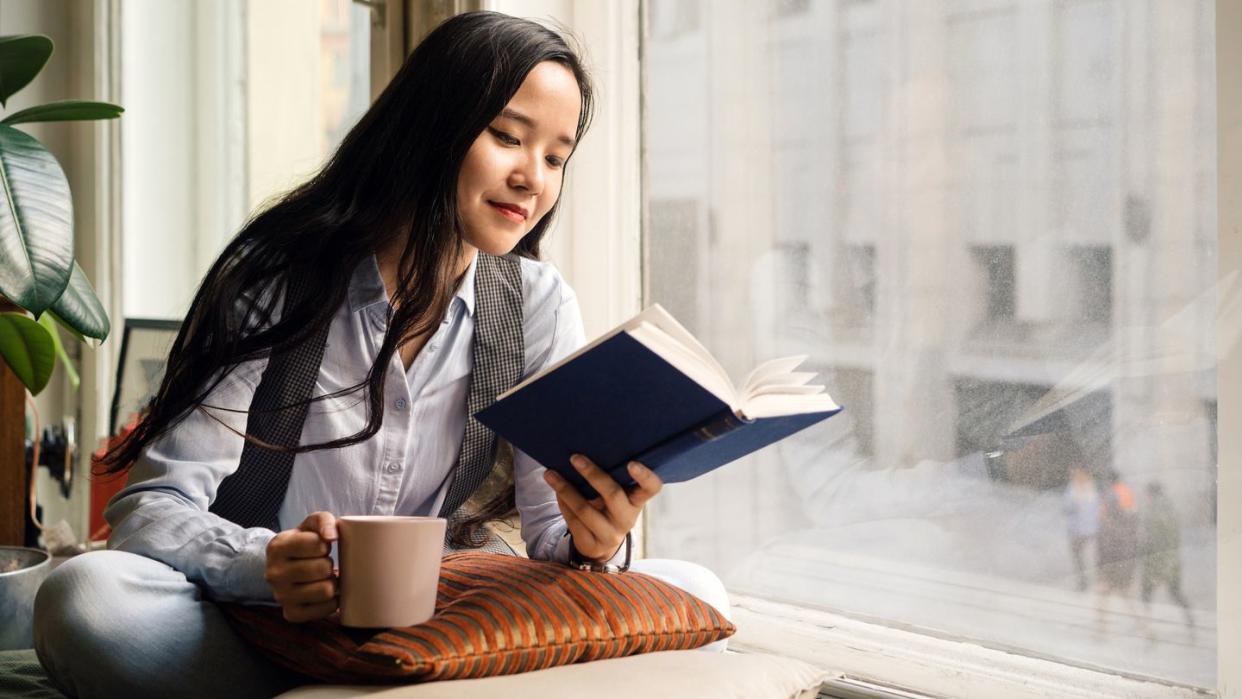 young woman in blue jeans reading