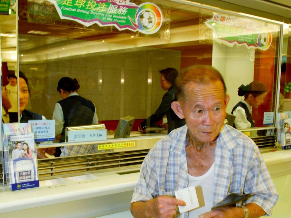 A Hong Kong man walks away after placing a bet on a soccer match at the Hong Kong Jockey Club off-course betting centre on the first day of legalised soccer betting in Hong Kong August 1, 2003. The Hong Kong government is facing a barrage of criticism over the decision to legalise soccer betting, a move which the government said would sweep many illegal soccer betting operations off the field.