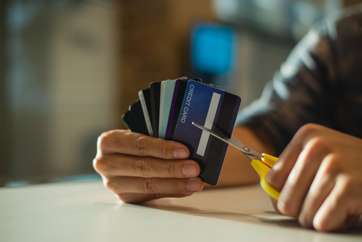 Young man cutting credit card with scissors,Man is destroying credit cards because of big debt.