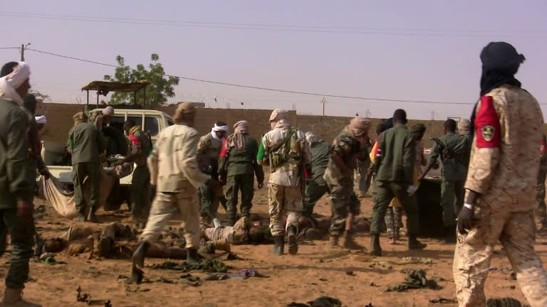 The dead and injured are evacuated following a suicide bomb attack that ripped through a camp grouping former rebels and pro-government militia in Gao, in northern Mali