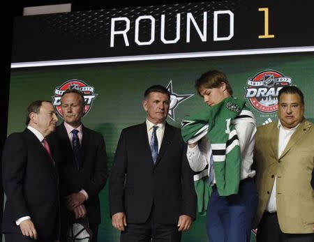 June 23, 2017; Chicago, IL, USA; Miro Heiskanen puts on a team jersey after being selected as the number three overall pick to the Dallas Stars in the first round of the 2017 NHL Draft at the United Center. Mandatory Credit: David Banks-USA TODAY Sports