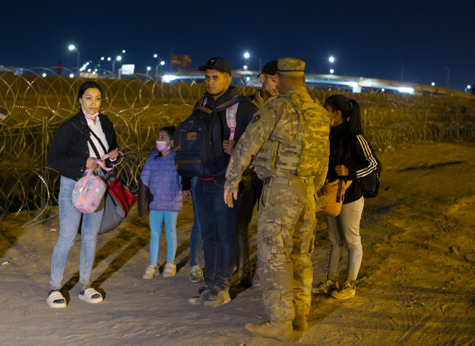 Migrants are stopped by a Texas National Guard soldier after crossing from Ciudad Juarez, Mexico into El Paso, Texas, in the early hours of Thursday, May 11, 2023. Migrants rushed across the border hours before pandemic-related asylum restrictions were to expire Thursday, fearing that new policies would make it far more difficult to gain entry into the United States. (AP Photo/Andres Leighton)