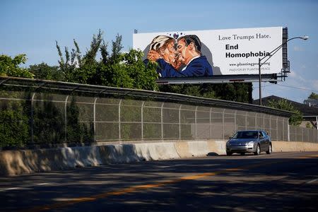 A billboard erected in advance of the Republican National Convention depicts U.S. Republican presidential candidate Donald Trump kissing former presidential candidate Sen. Ted Cruz (R-TX) in Cleveland, Ohio July 15, 2016. REUTERS/Aaron P. Bernstein