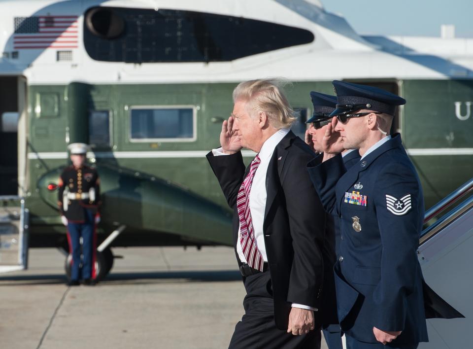 President Donald Trump salutes as he steps off Air Force One at Andrews Air Force Base in Maryland upon his return from Philadelphia on January 26, 2017.&nbsp;