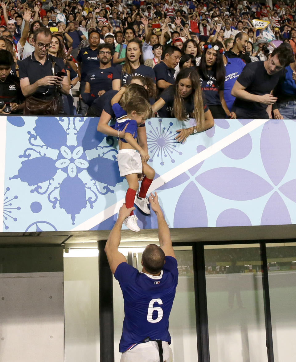 France's Wenceslas Lauret takes a young boy from the crowd following their Rugby World Cup Pool C game at Kumamoto Stadium against Tonga in Kumamoto, Japan, Sunday, Oct. 6, 2019. (AP Photo/Aaron Favila)