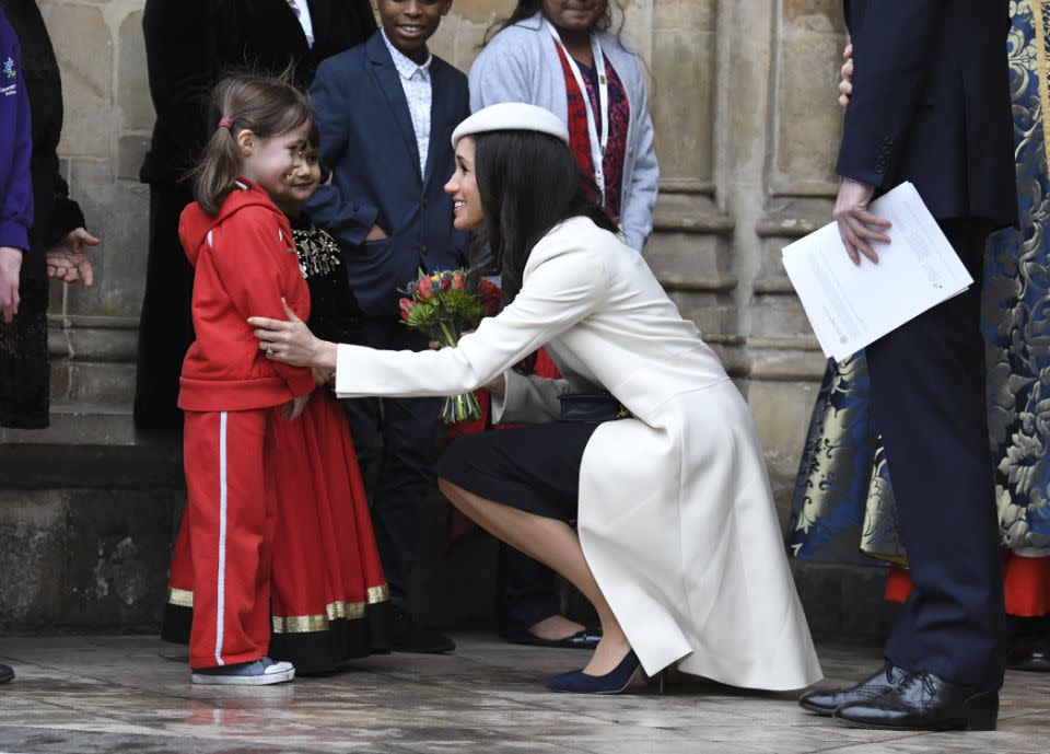 Meghan was handed a bunch of flowers by a girl outside of Westminster Abbey. Photo: Getty