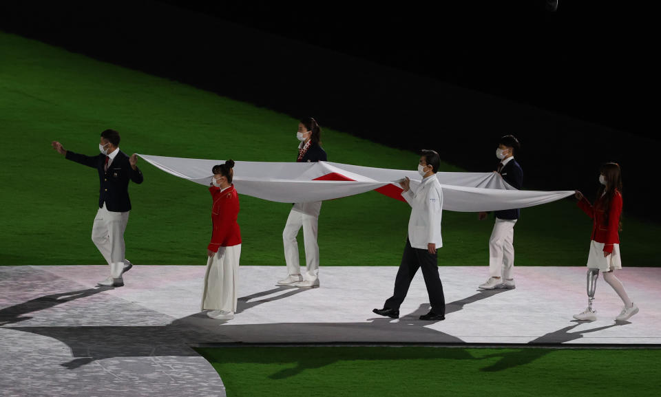 TOKYO, JAPAN - AUGUST 8, 2021: The Japanese national flag is carried during the closing ceremony of the 2020 Summer Olympic Games at the Japan National Stadium (a.k.a the Olympic Stadium). The Olympic Games were held amid the COVID-19 pandemic. The closing ceremony features live and pre-recorded elements. Stanislav Krasilnikov/TASS (Photo by Stanislav Krasilnikov\TASS via Getty Images)