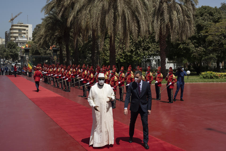 Senegal's President Macky Sall, left, welcomes Spanish Prime Minister Pedro Sanchez prior to a meeting at the presidential palace in Dakar, Senegal, Friday, April 9, 2021. Sanchez is on a mini-tour to Angola and Senegal that are key in the European country's new push to bolster ties with the neighboring continent and mitigate the migration flows that many fear could increase as a consequence of the coronavirus pandemic. (AP Photo/Leo Correa)