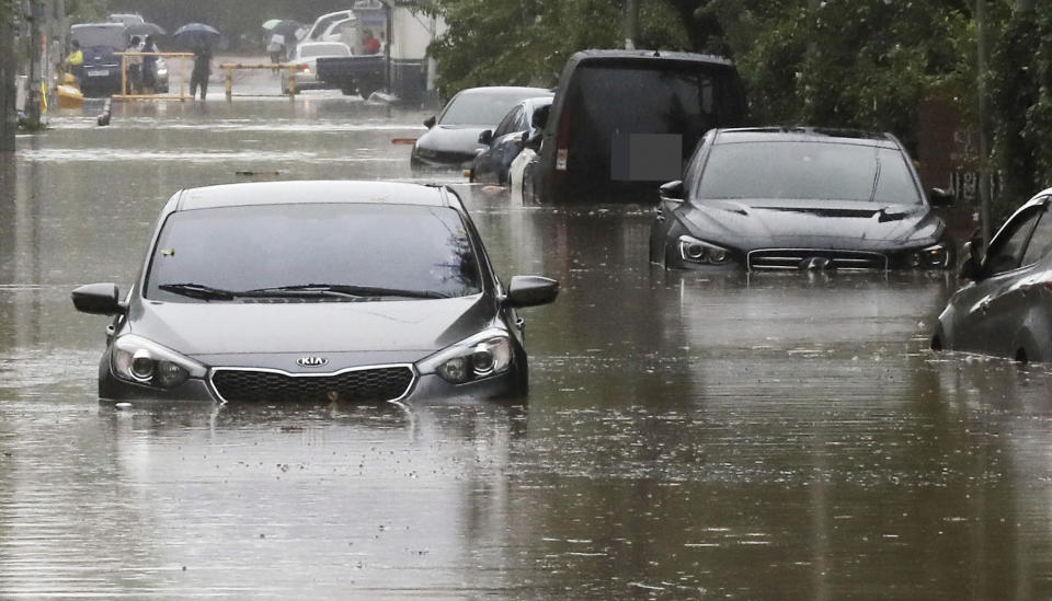 Vehicles are submerged in floodwaters caused by the tropical storm named Khanun in Changwon, South Korea, Thursday, Aug. 10, 2023. The strong tropical storm blew ashore in South Korea on Thursday morning, dumping heavy rain and pummeling its southern regions after thousands of people were evacuated. (Chung Jong-ho/Yonhap via AP)