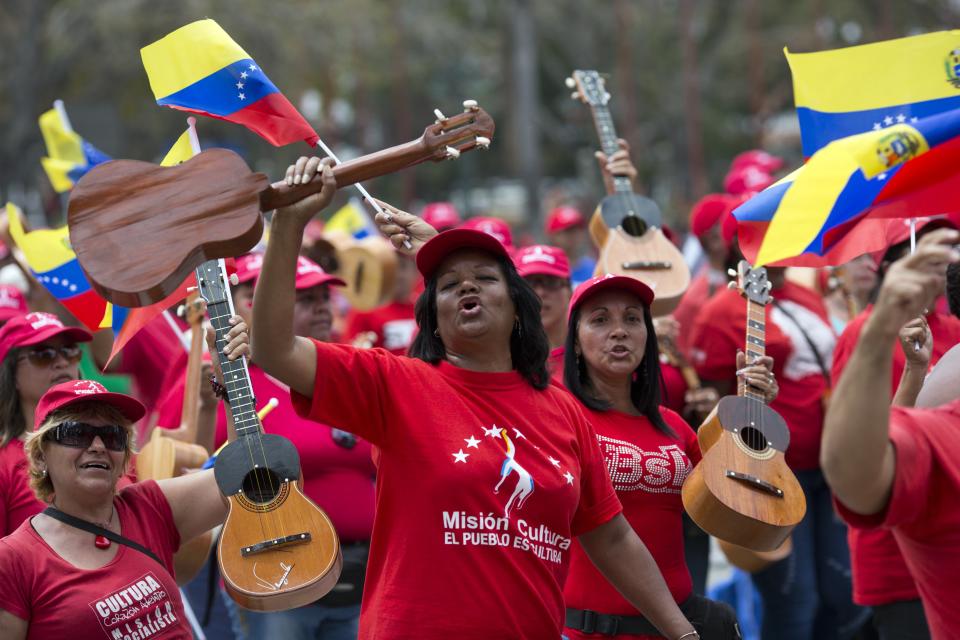 Government supporters parade during a military parade commemorating the one year anniversary of the death of Venezuela's former President Hugo Chavez in Caracas, Venezuela, Wednesday, March 5, 2014. The anniversary of Chavez's death was marked with a mix of street protests and solemn commemorations that reflected deep divisions over the Venezuela he left behind. (AP Photo/Rodrigo Abd)