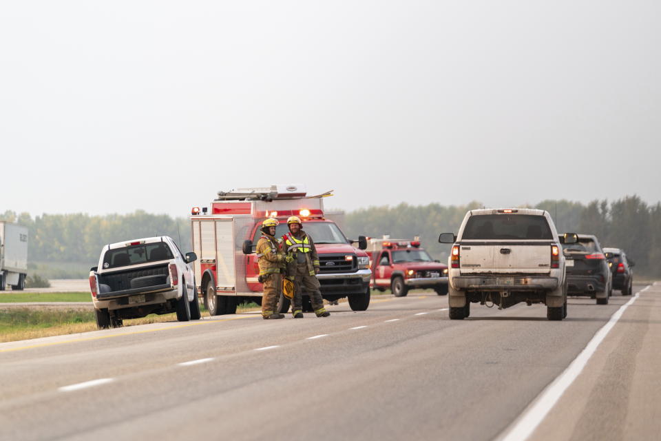 Firefighters gather at the scene where a stabbing suspect was arrested in Rosthern, Saskatchewan on Wednesday, Sept. 7, 2022. Canadian police arrested Myles Sanderson, the second suspect in the stabbing deaths of multiple people in Saskatchewan, after a three-day manhunt that also yielded the body of his brother fellow suspect, Damien Sanderson.(Heywood Yu/The Canadian Press via AP)