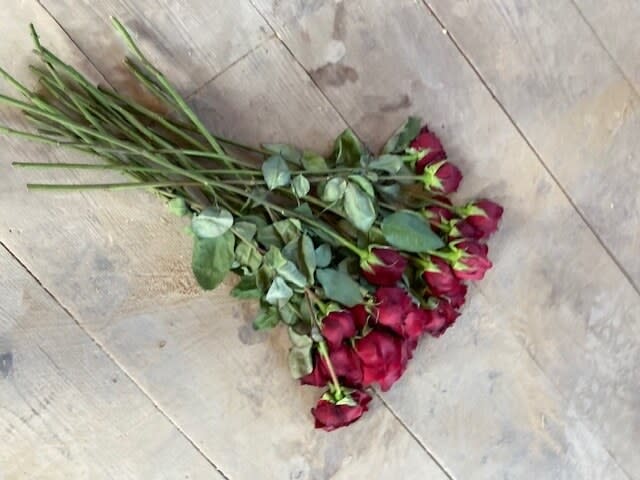 A bouquet of roses left at the Rust shooting scene with traces of blood on and around them.