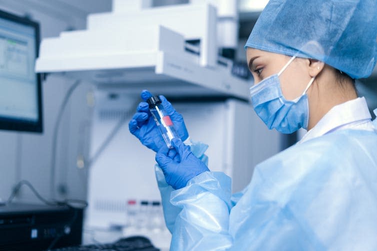 A lab researcher holding a vial