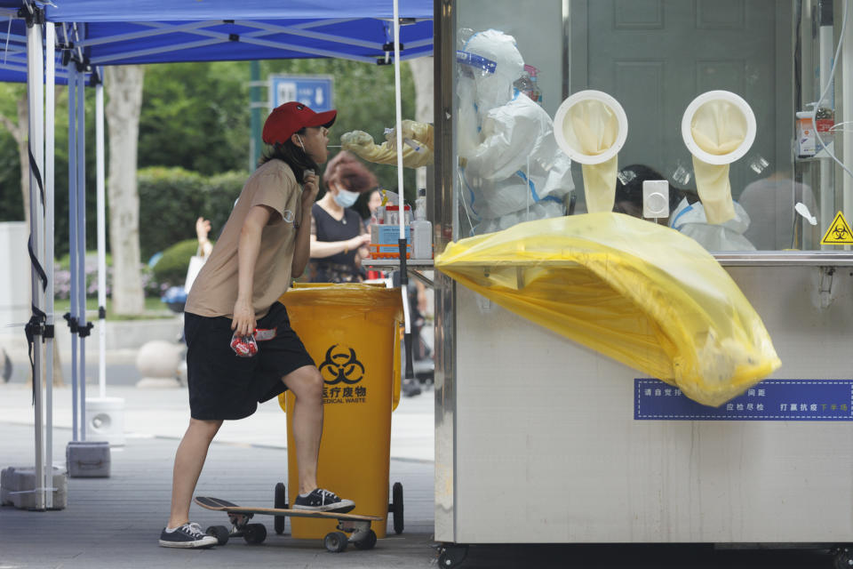 SHANGHAI, CHINA - JULY 07: A girl with a skateboard
 gets a COVID-19 test at a testing station on July 07, 2022 in Shanghai, China. (Photo by Hugo Hu/Getty Images)