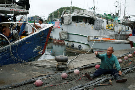 A fisherman arranges a net as Typhoon Nepartak approaches in Yilan, Taiwan July 7, 2016. REUTERS/Tyrone Siu