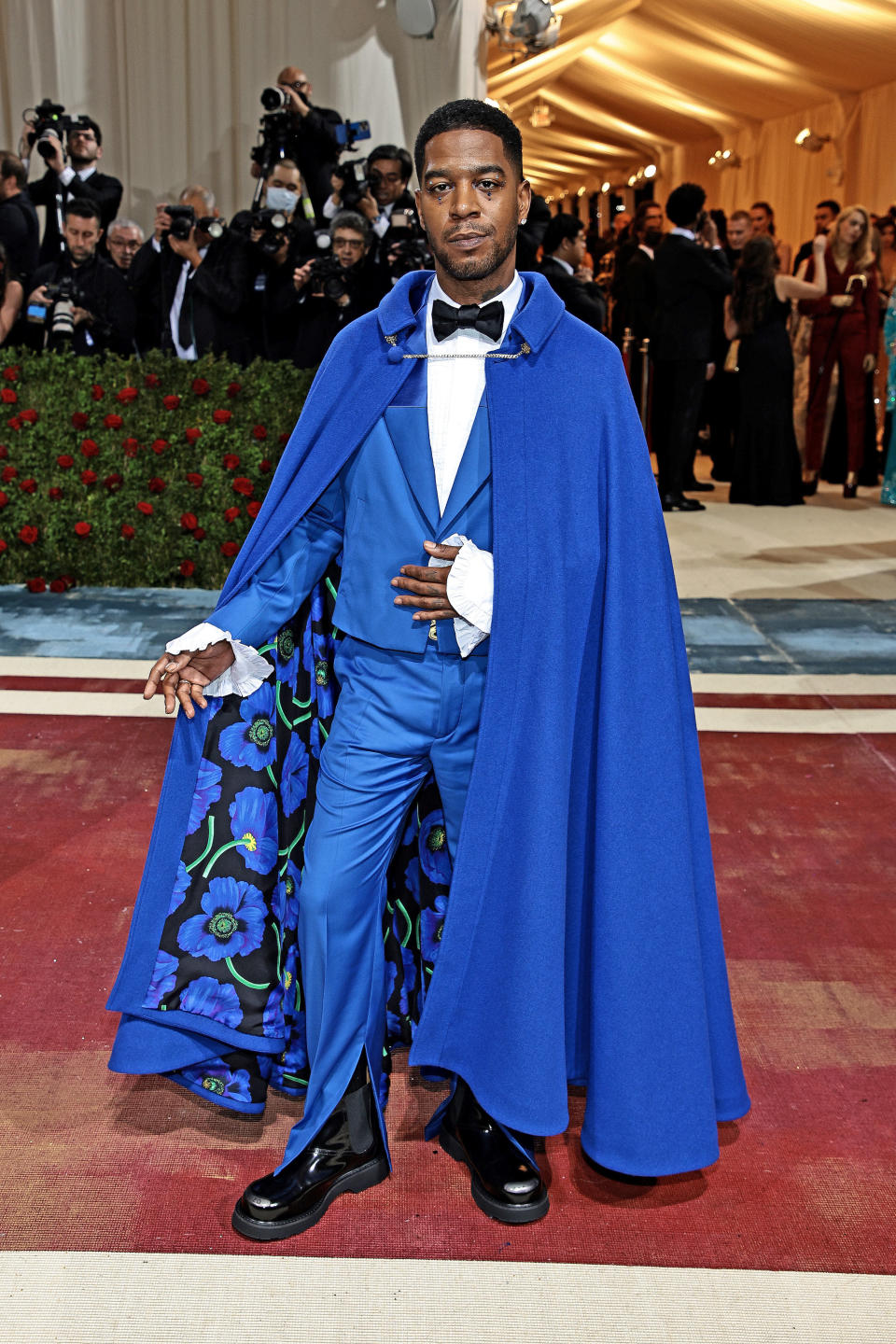 Kid in a suit and bow tie with matching long cape