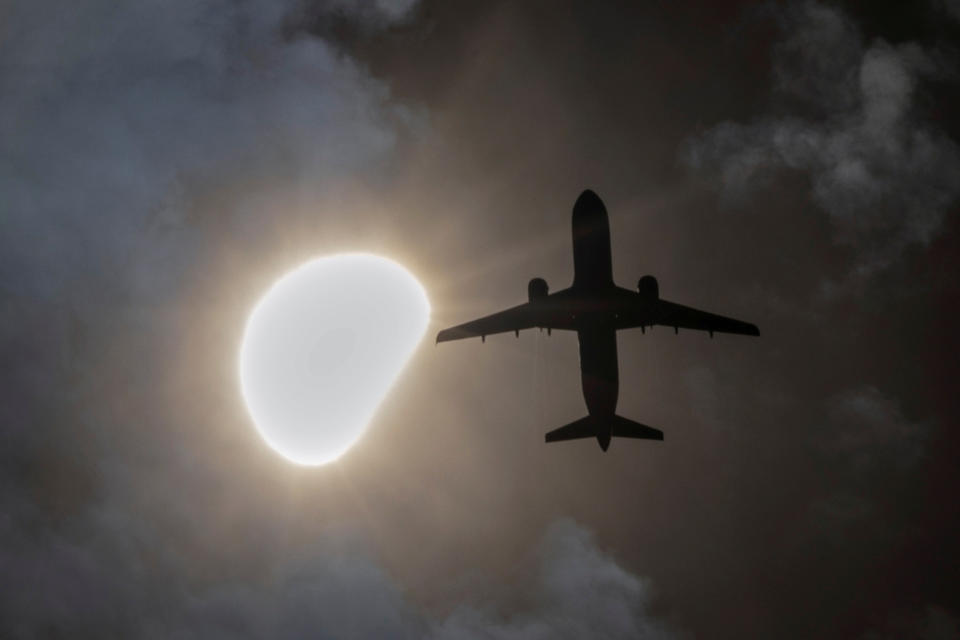 Ein Flugzeug fliegt während einer partiellen Sonnenfinsternis vorbei, gesehen von Queens, New York City, USA (Bild: REUTERS/Andrew Kelly/TPX IMAGES OF THE DAY)