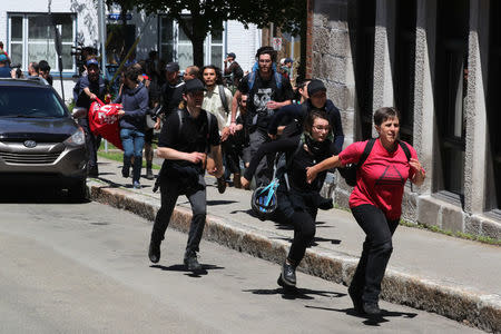 Protesters run from riot police during the G7 Summit in Quebec City, Quebec, Canada, June 8, 2018. REUTERS/Jonathan Ernst