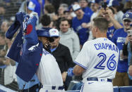 Toronto Blue Jays' Teoscar Hernandez receives a home-run jacket from Matt Chapman (26) after Hernandez's three-run home run against the Texas Rangers during the fifth inning of a baseball game Friday, April 8, 2022, in Toronto. (Nathan Denette/The Canadian Press via AP)