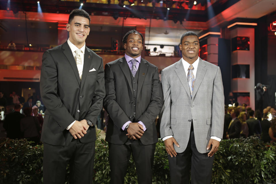 Heisman Trophy candidates, from left, Oregon's Marcus Mariota, Wisconsin's Melvin Gordon and Alabama's Amari Cooper pose for a photo at the College Football Awards, Thursday, Dec. 11, 2014, in Lake Buena Vista, Fla. The winner of the Heisman Trophy will be announced on Saturday. (AP Photo/John Raoux)