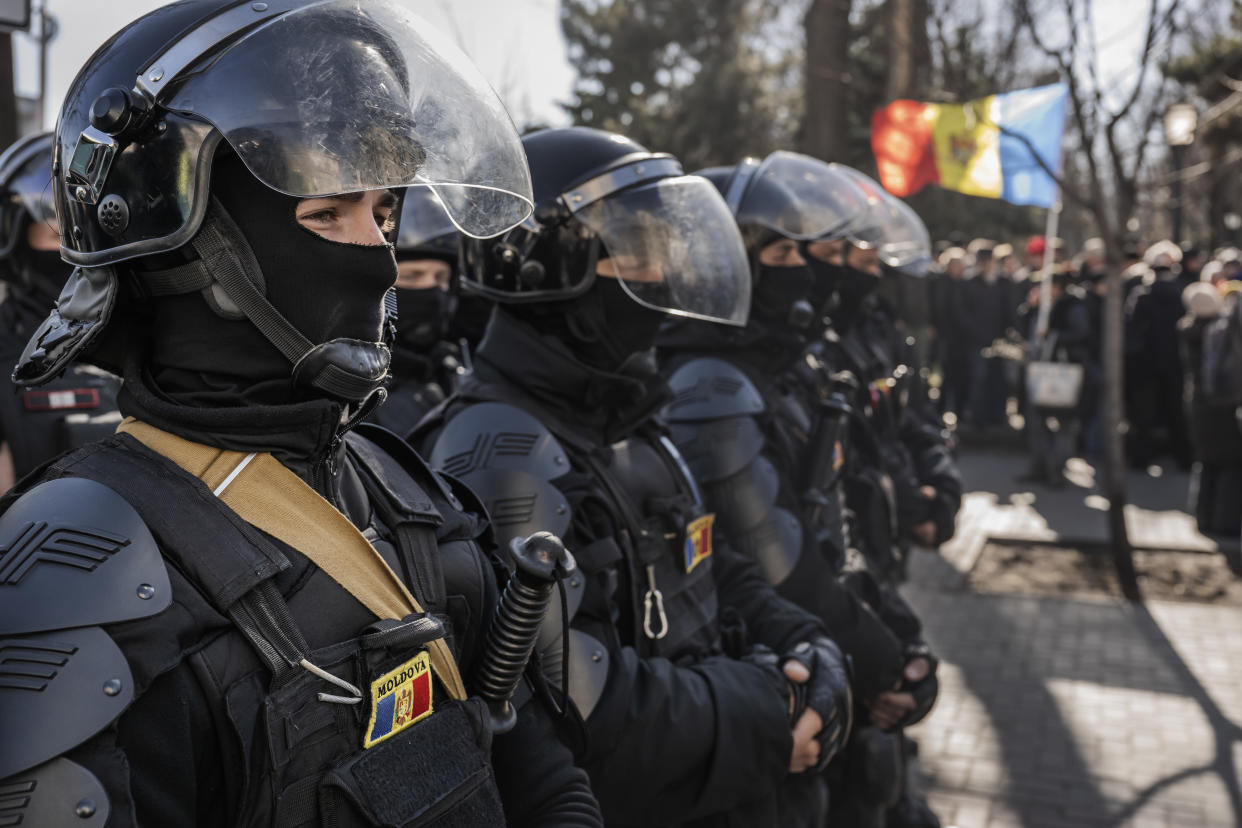 Moldovan forces face protesters in a city street.