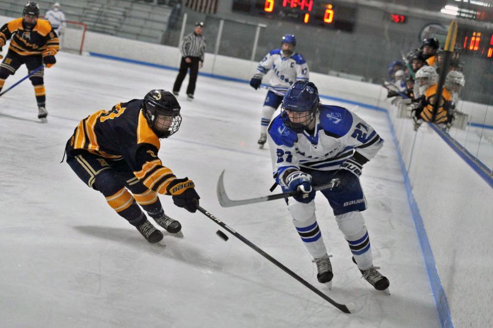 Hanover's Bill Radzik, left, and Scituate's Luke Ryan, right, battle for the puck during boys high school hockey action at the Hobomock Arena in Pembroke, Wednesday, Feb. 7, 2024.